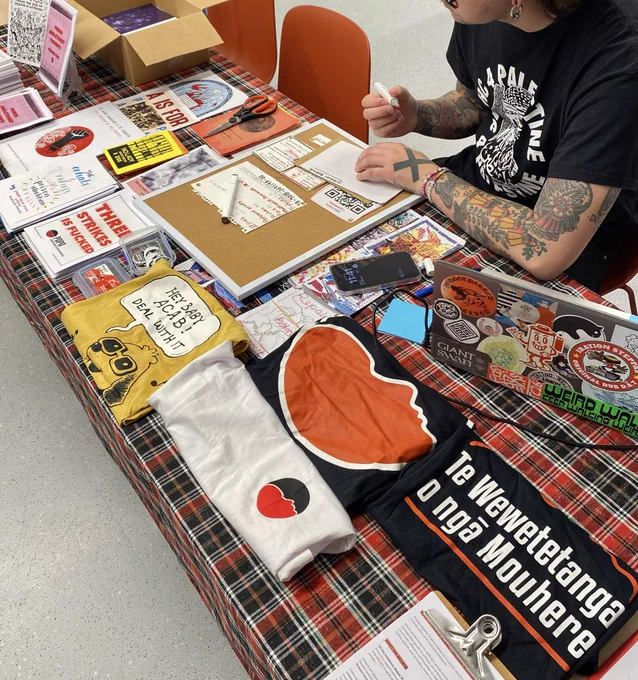 Image description: Picture of people writing cards at the Pōneke 2026 Matariki Holiday Card Drive. 