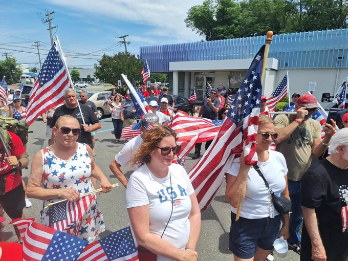 Greg Hach is surrounded by hundreds of supporters as he marches in the Flag Day march at the Embassy Diner in Bethpage, NY. 