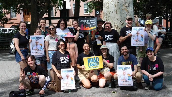 JFREJ members standing together for a photo while holding up campaign signs.