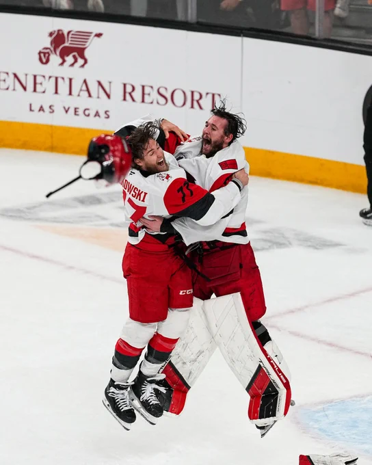 Brandon Bussi and Mark Jankowski celebrate winning the Stanley Cup on ice in Hurricanes uniforms.