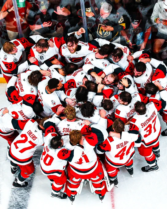 Photo of the Carolina Hurricanes in Carolina Hurricanes uniforms hugging after winning