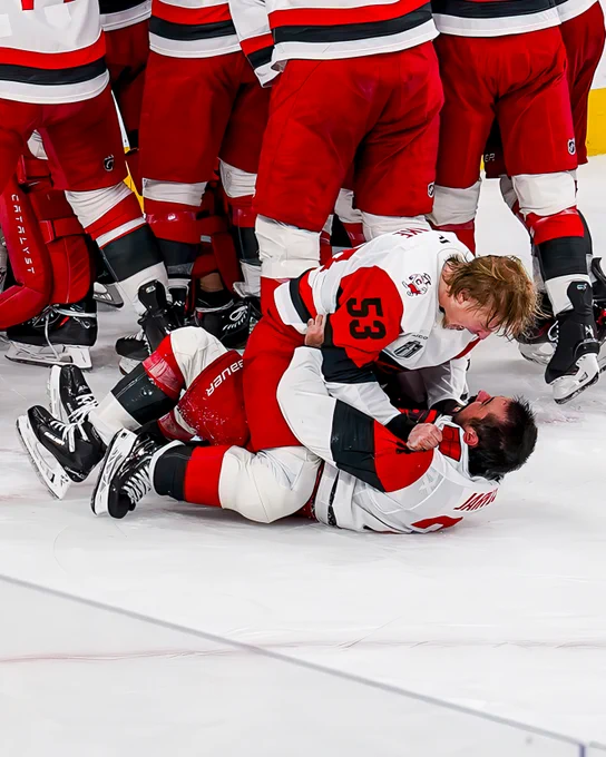 Photo of Seth Jarvis and Jackson Blake celebrating winning the Stanley Cup on ice in Hurricanes uniforms