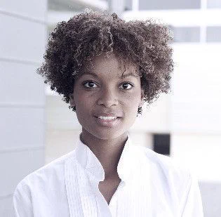 Young Black woman wearing a white corporate shirt.