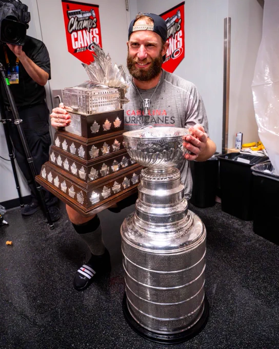 Jordan Staal takes a photo with the Stanley Cup and Conn Smythe Trophy. 