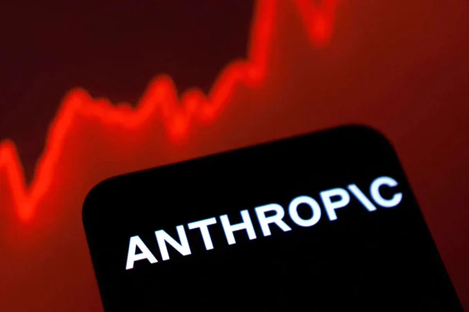 Close-up of the white Anthropic logo displayed on a device against a blurry red stock market line graph background, highlighting security risk interventions.