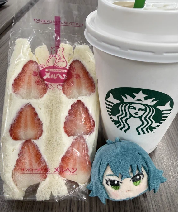 いちごのサンドイッチとスターバックスコーヒーのカップ、つきむらてまりのぬいリングが並んでいる。