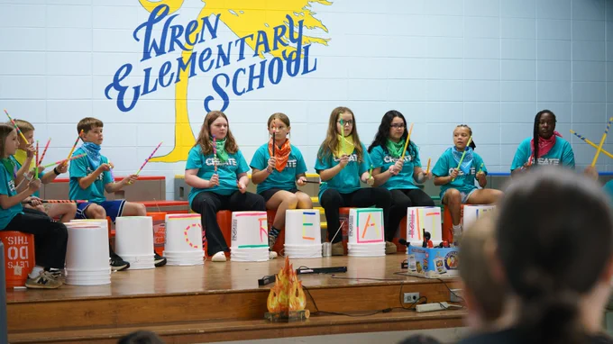 Students playing the drums on stage during the CREATE program showcase