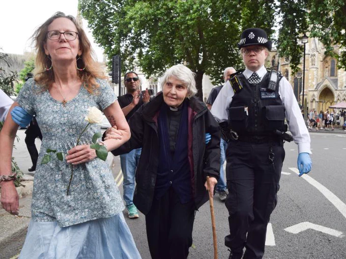 Two women being arrested - one of whom is a vicar.