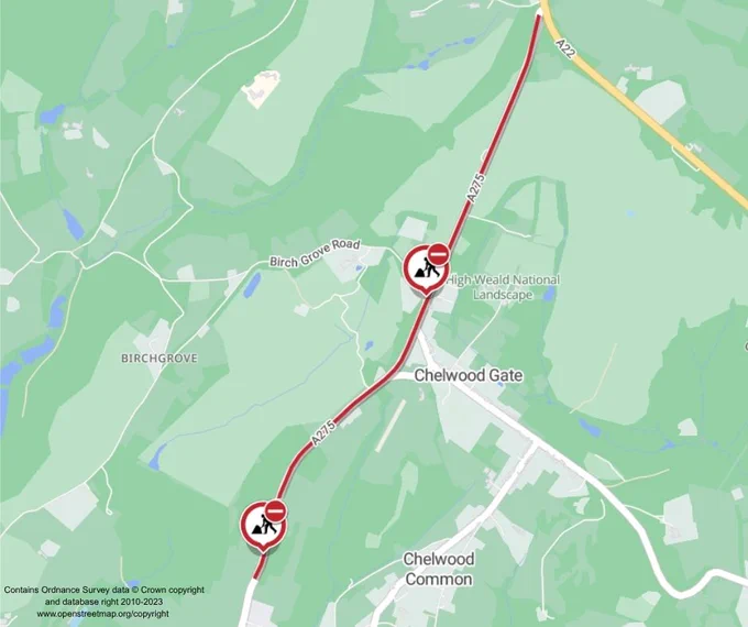 A map displaying a section of the A275 road passing through the High Weald National Landscape and near Chelwood Gate and Chelwood Common. The map shows the positioning of roadworks with two caution symbols along the A275. The background features green areas representing land and white areas for roads and urban areas.