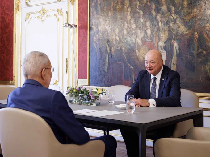 Bundespräsident Alexander Van der Bellen und Bundeskanzler Christian Stocker sitzen sich an einem Tisch gegenüber.