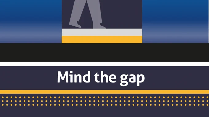 A stylised railway safety graphic showing a train platform edge and the lower legs of a passenger stepping near the gap between the train and platform. The words "Mind the gap" are displayed prominently in large white text against a dark blue background, with yellow safety markings and tactile paving dots along the bottom of the image.