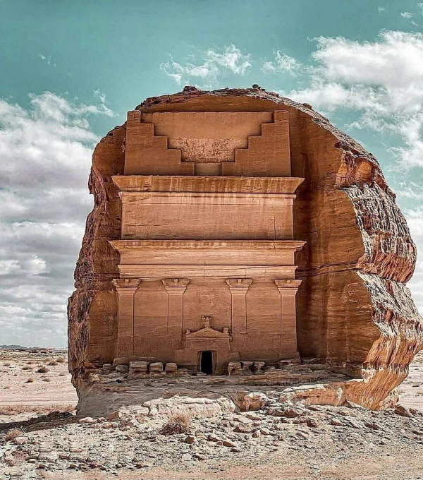 🏜️ The Desert Tomb That Still Watches…

Hidden deep in the silent sands of northwestern Saudi Arabia lies a massive rock carved with incredible precision—standing alone, as if guarding secrets no one has fully uncovered. This is part of Hegra (Al-Hijr), an ancient city built by the mysterious Nabataean civilization nearly 2,000 years ago.

At first glance, it looks like a grand doorway… but it leads nowhere. No windows, no life—just a tomb carved straight into stone for a powerful family of a forgotten era. The details are shocking—perfect columns, sharp edges, and elegant designs that have survived centuries of wind and sand. How did they achieve such precision in the middle of a harsh desert?

But here’s where it gets strange…

This place once stood along powerful trade routes, where caravans carried spices, incense, and untold riches across continents. Wealth flowed here. Stories were exchanged here. And then… silence.