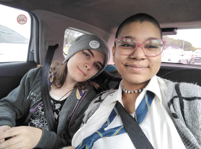 A picture of Ms. Quick and Ames in the backseat of a car. We are wearing cute "going out" clothes and look very autistic and gay.