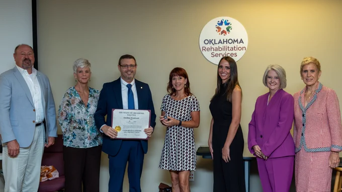 Two smiling men and five smiling women.