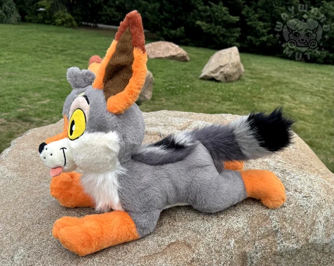 profile view of yote plush. he has long fur on his back and tail. he is 20 inches long.