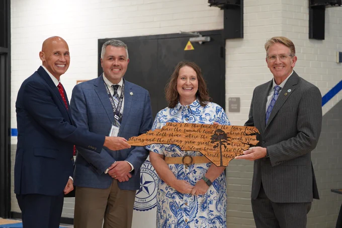 group photo. an NC wooden plaque is presented to an individual 