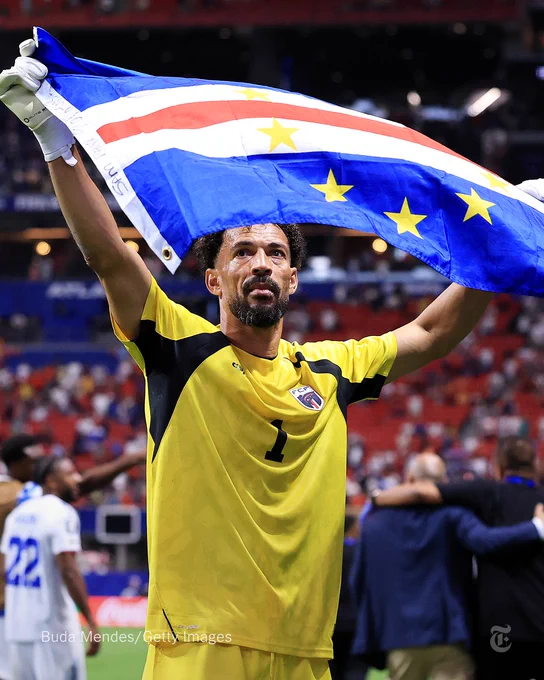 Vozinha, the goalkeeper of Cabo Verde, holds up a flag to celebrate their draw against Spain.