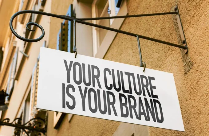 A sign hanging from a Brown outside wall which reads 'Your Culture is Your Brand.'