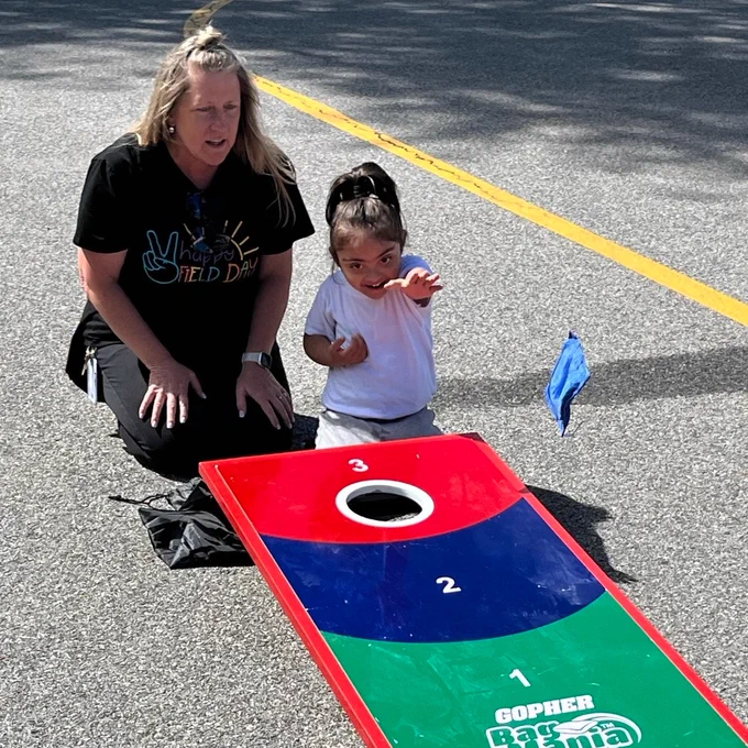 teacher and student play corn hole
