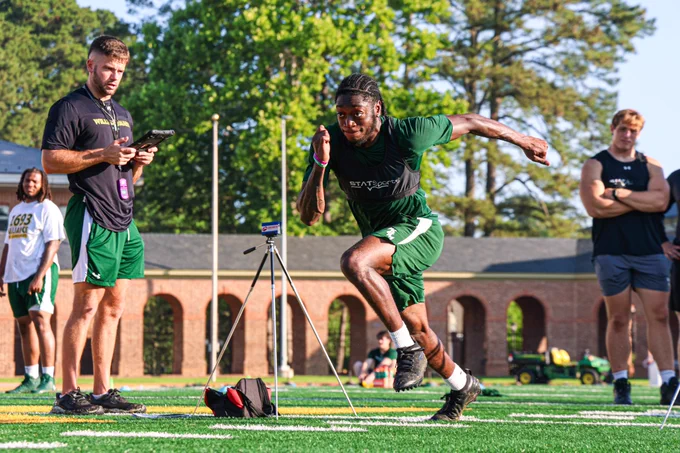 Trevon Cannon does a running drill while coaches and teammates observe during summer workouts at Zable stadium.
