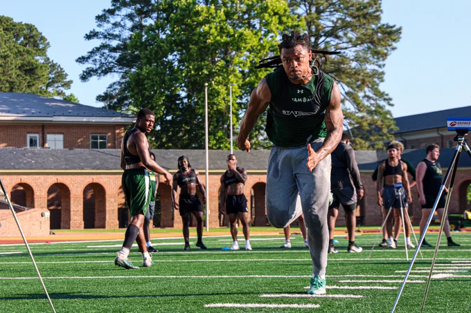 Josh Miller does a timed run as teammates watch at Zable Stadium during summer workouts. 