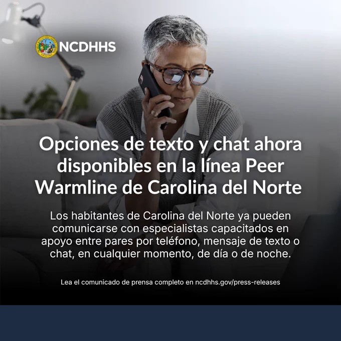Una persona con el cabello corto y gafas está usando un teléfono inteligente. El texto dice: "Opciones de mensajes de texto y chat ya disponibles en la línea de apoyo entre pares de Carolina del Norte. Los residentes de Carolina del Norte ahora pueden comunicarse con especialistas capacitados en apoyo entre pares por teléfono, mensaje de texto o chat en cualquier momento, de día o de noche". En la parte superior se ve el logotipo del Departamento de Salud y Servicios Humanos de Carolina del Norte (NCDHHS).