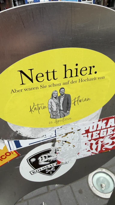 Ein gelber Aufkleber mit »Nett hier, aber waren Sie schon auf der Hochzeit von Katrin und Florian«