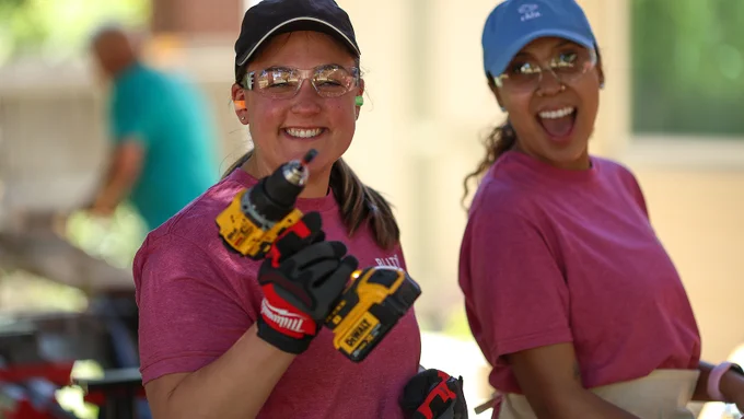 Two CHFA staff members, one holding a drill, smiling for the camera at the June 2026 Blitz Build.