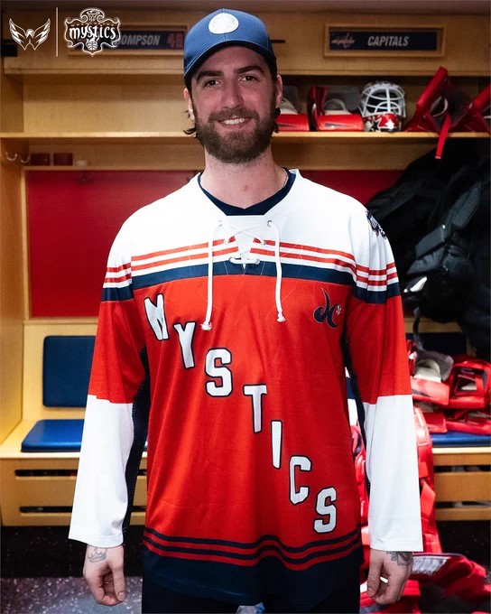 Logan Thompson smiles while sporting the Washington Mystics x Washington Capitals crossover jersey.