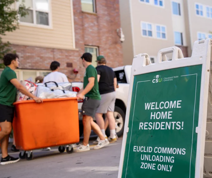 CSU students unloading cars and moving into Euclid Commons. A sign reads, "Welcome Home Residents."