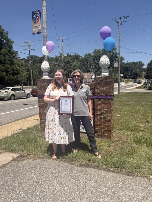 Two women holding up a plaque and smiling