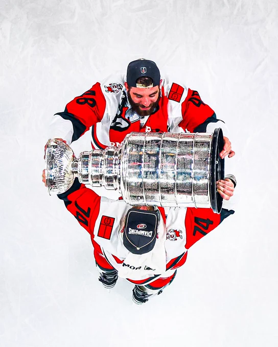 Overhead photo of Jordan Martinook and Jaccob Slavin hoisting the Cup