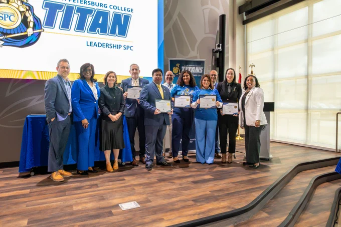 SPC employees and graduates of Leadership SPC stand holding their certificates alongside college President, Tonjua Williams.