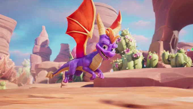 A purple dragon with orange wings and horns flies through a desert landscape with cacti and rock formations under a blue sky.