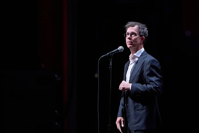 Ben Folds standing in front of a microphone.