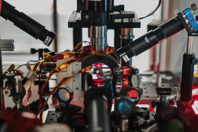 The 'cloud' inside the glass cell is a magneto-optical trap of rubidium atoms at a temperature of ~0.0001 degrees above absolute zero. It is only the first step to "build" the mini-universe. (Credit: University of Birmingham)