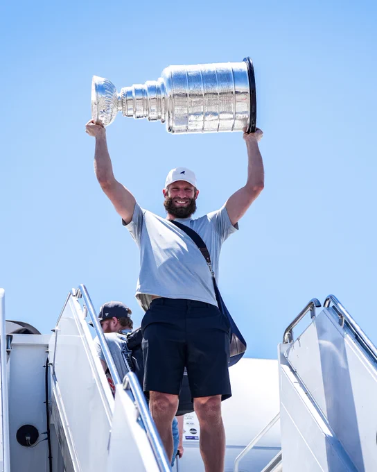 Photo of Jordan Staal hoisting the Cup on the steps of the plane 