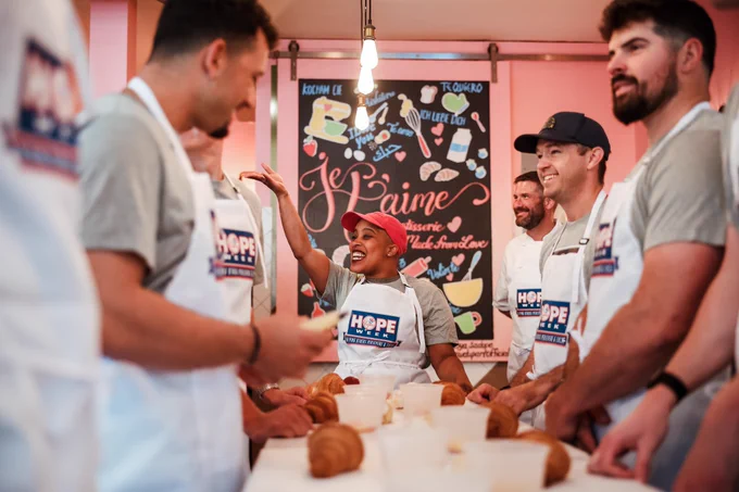 HOPE Week Honoree Jatee Kearsley instructs Yankees players and coaches on how to bake while at her Bed-Stuy bakery, Je T’aime Pâtisserie. 