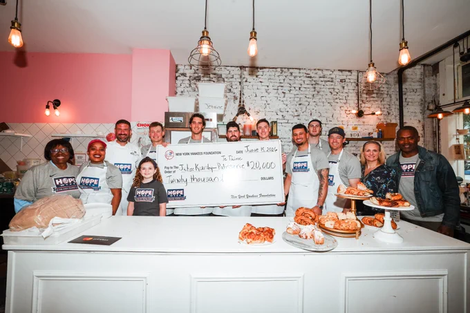 The Yankees present HOPE Week Honoree Jatee Kearsley with a $20,000 donation at her Bed-Stuy bakery, Je T’aime Pâtisserie. 