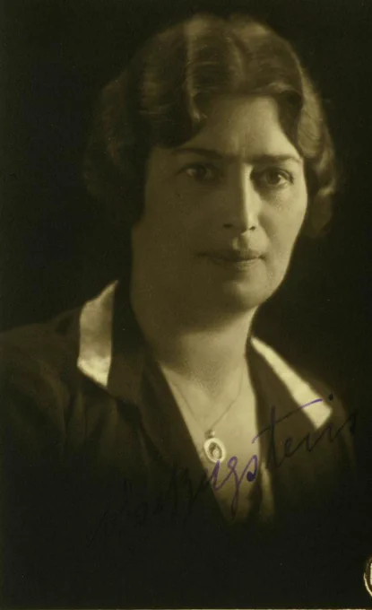 Vintage portrait of a woman featuring her in a dark blouse with a serious expression.
