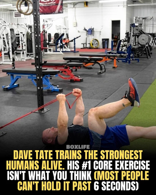 A man demonstrates a challenging core exercise with resistance bands in a gym setting. The exercise is described as difficult for most people.