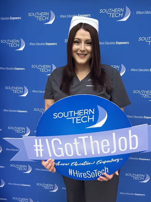student holding an I got the job sign.