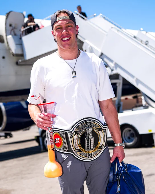 Photo of Taylor Hall with the Stanley Cup belt outside the plane