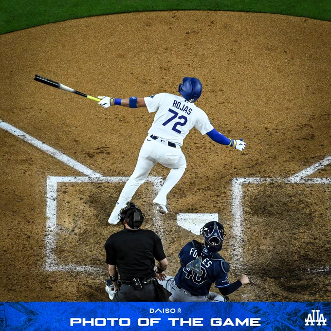 A photo of Miguel Rojas holding the bat and watching the ball fly after hitting a pinch-hit home run to put the Dodgers ahead.