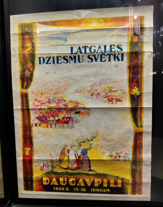 Karteņā: Vīns nu Breivvaļsts duorgumu noma Rēzeknē eksponatu ir 1940. gods Latgolys dzīšmu svātku afiša, kurys autore ir Marija Induse-Muceniece, plakats izgataveits Reigā, Vārtspapeiru spīstuvē

