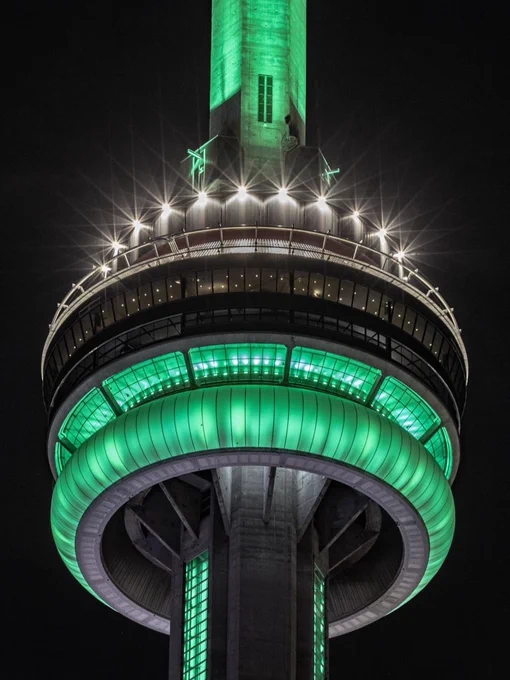 Closeup of the CN Tower at night lit green/ Gros plan de la Tour CN illuminée en vert la nuit 
