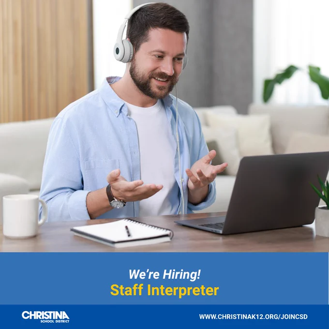 A male sitting at a desk with earphones, using American Sign Language at a computer while on an online meeting. Christina School District logo bottom left. WWW.CHRISTINAK12.ORG/JOINCSD.