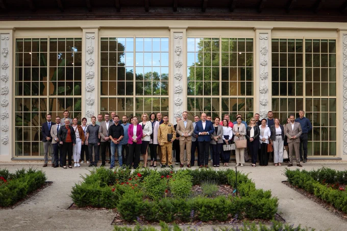 Spotkanie z lokalnymi NGO z podkarpacia. Szeroki kadr, zdjęcie grupowe. Grupa ponad trzydziestu osób pozuje do wspólnego zdjęcia. Widoczna między innymi Sekretarz Stanu Adriana Porowska.