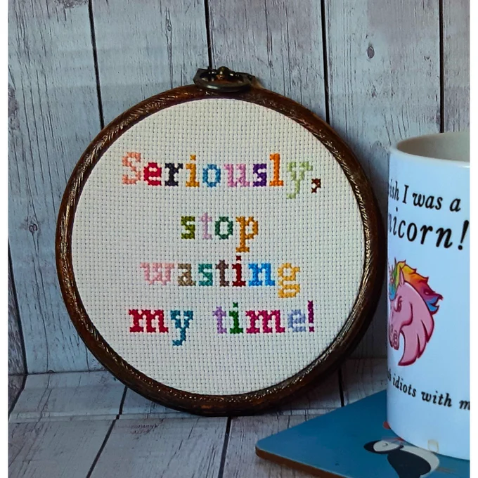 4 inch embroidery hoop in multicoloured letters saying 'Seriously, stop wasting my time!'