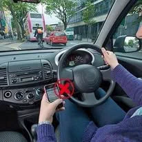 Image of a driver with a mobile in their hand. 